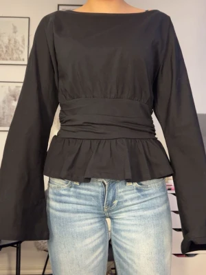 Svart blus med volang och markerad midja - Säljer en helt ny svart blus med långa ärmar, markerad midja och volang nedtill. Då den tyvärr är förstor för mig och har inte orkat skicka tillbaka den. Jag har aldrig använt den lappar och sånt finns kvar