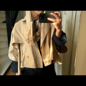 Beige kort trenchcoat från COS - !Intressekoll! Jätte fin trench cape ifrån COS! Oanvänd, tyvärr har lappen åkt av men snöret till lappen är forfarande kvar! Säljs inte längre och super eftertraktad! Kom med prisförslag, säljer för bra bud!! 