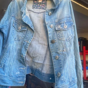 Blå jeansjacka från Denim Co - Säljer en snygg blå jeansjacka från Denim Co i storlek 38. Jackan har en klassisk design med knappar framtill och två bröstfickor med lock. Perfekt för vår och sommar! 💙