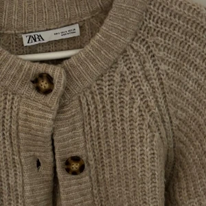 Beige stickad kofta från Zara - Säljer en superfin beige stickad kofta från Zara. 