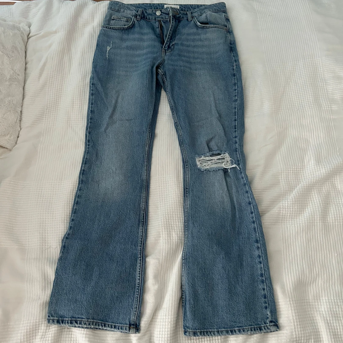 Blå jeans med slitningar
