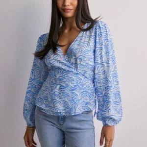 Wrap Top - säljer denna fina toppen från nelly! nypris 329kr säljer då den inte kommer till användning, fint skick och knappast använd!