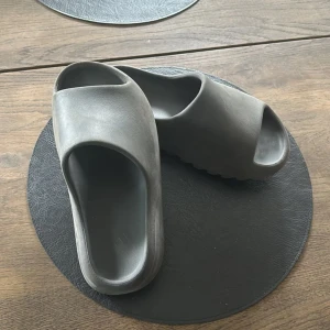 Yeezy slides - Ett par knappt använda yeezy slides i färgen/grå svart. Inget smuts och inte sönder någonstans