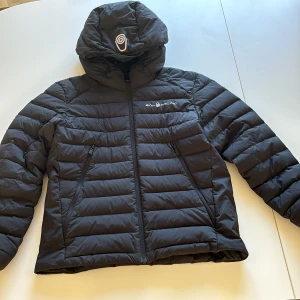 Sail Raicing jacka strl 150 - Sail Raicing jacka JR Spray Down Hood lättviktsdun strl 150. I nyskick säljes för 1000:-, nypris 2299:-