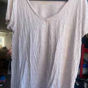 Beige t-shirt från H&M - Säljer en enkel och bekväm gammalrosa t-shirt från H&M. Den har en v-ringad hals och korta ärmar, perfekt för vardagsbruk. Materialet känns mjukt och skönt mot huden. Passar bra till både jeans och shorts!
