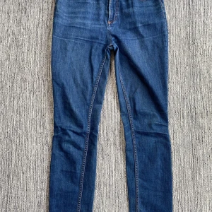 Blåa jeans i strl 28” från Marc by Marc Jacobs, modell Ella skinny. - Blåa jeans i strl 28” från Marc by Marc Jacobs, modell Ella skinny.  Använda men i fint begagnat skick.  Mått Midjan: ca 39 cm Längd från grenen och ner: ca 75 cm  93% bomull, 6% polyester och 1% elastan  Kommer från ett djur och rökfritt hem.