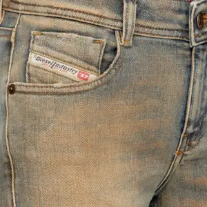 Mid waist jeans i en blå färg med bruna toner från Diesel. Storlek 27