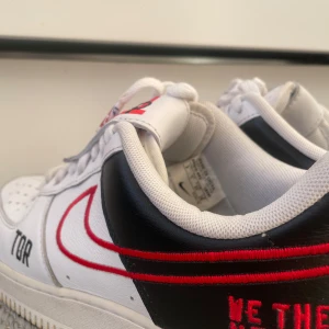 Nike Air Force 1 - Toronto Raptors Nike Air Force 1 'We The North' i vitt, rött och svart.  Snygga och bekväma sneakers med en unik design.   • Skorna är använda och ser ut som på bilderna. • Helt intakta, dvs inga hål, separationer eller slitage på material.