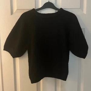 Svart tröja från Lindex - Säljer en stilren svart tröja från Lindex. Tröjan har en enkel design med korta ärmar och rund halsringning. Perfekt för en minimalistisk look.