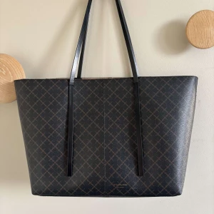 By Malene Birger väska  - Jätte fin ByMaleneBirger väska. Köpt ny för fullt pris. Svart med mörk bruna mönster. Passar till allt och är väldigt stilig. Några trådar i väskan och små fläckar. Inget som syns på utsidan.