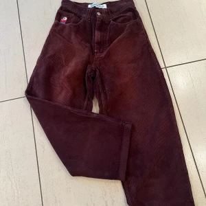 Bruna manchesterbyxor från Big Boy - Snygga bruna manchesterbyxor från Big Boy med broderad detalj på fickan. Byxorna har en loose passform och är perfekta för en avslappnad stil. De har en klassisk design med två bakfickor och bälteshällor. Nyskick