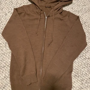 Brun hoodie från Stenströms - Snygg brun hoodie från Stenströms med dragkedja och huva. Perfekt för en avslappnad stil. Den har långa ärmar och ribbade muddar för extra komfort. Skriv om du undrar något 👌🏻