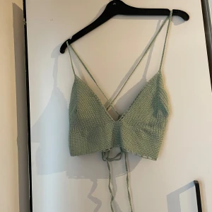 Virkad topp - Grön virkad topp i tunnt garn. Justerbar knytning i ryggen men skulle säga s-m