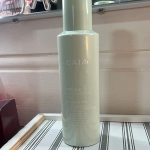 CAIA Step One Heat Protection - Cirka halva kvar. CAIA Step One Heat Protection är en värmeskyddande spray med marine alga-sugar complex som skyddar håret mot värmeskador. Produkten återfuktar och ger glans, perfekt för styling. Innehåller 150 ml.