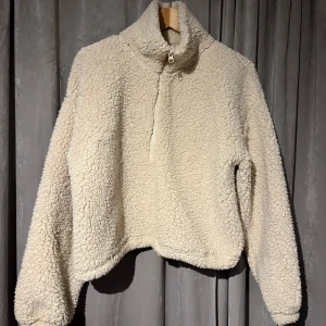 Beige fleecejacka från Bik Bok - Mysig beige fleecejacka från Bik Bok med dragkedja och hög krage. Perfekt för kyliga dagar när du vill hålla dig varm och bekväm. Jackan har en avslappnad passform och är supermjuk.