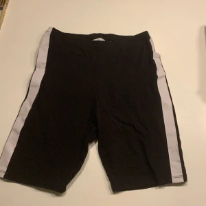 Cykelbyxor  - Dom vita linjerna är lite skadade men syns inte lika mycket på långt håll. De är 38 cm långa.