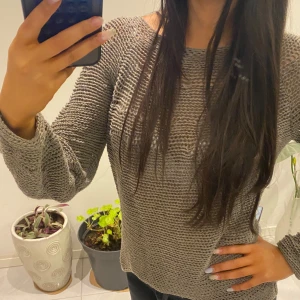 Grå stickad tröja - Säljer en stilren grå stickad tröja med långärmad design. Perfekt för lager-på-lager och ger en avslappnad look. Tröjan har en luftig stickning som gör den bekväm och lätt att bära.