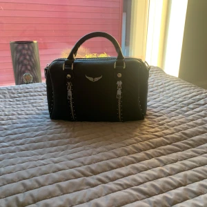 Svart handväska med dragkedja - Snygg svart handväska med coola dragkedjedetaljer.