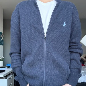 Svart kofta från Polo Ralph Lauren - Säljer denna sjukt snygga Ralph lauren zip up för bara 849kr! Koftan är i puma cotton som är ett exklusivt elegant tyg. Skicket är 9/10 | killen på bilden är ungefär 168cm lång.