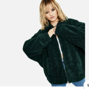 Mörkgrön teddyjacka från Urban Outfitters - Säljer en mysig mörkgrön teddyjacka från Urban Outfitters. Jackan har en dragkedja framtill och är perfekt för vår/höst dagar. Är oversized i storlek s. 