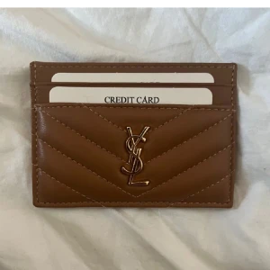 kortfodral/plånbok - Snyggt brunt kortfodral/plånbok. Perfekt för att hålla dina kort organiserade med stil. Den har plats för flera kort och är lätt att bära med sig. LÅNADE BILDER!