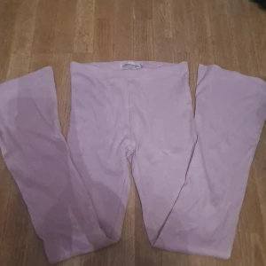 Rosa leggings - Säljer ett par mjuka rosa leggings i ribbat material. Perfekta för en avslappnad stil eller som ett bekvämt lager under andra kläder.