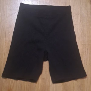 Svarta ribbade shorts - Säljer ett par svarta ribbade shorts med hög midja. Perfekta för en avslappnad stil eller träning. De har en tight passform som ger en bekväm känsla.