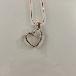 Guld halsband  - Ett guld  halsband med en hjärtformad berlock. Som är ny och aldrig använd. Smycket kommer från Smycka.