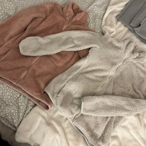 Mysiga fleece i rosa och vit - Säljer två supermjuka fleece jackor i rosa och vit. Perfekta för kyliga dagar med dragkedja och hög krage. Jackorna har långa ärmar och är gjorda av fluffigt material som håller dig varm och bekväm. Nypris 400 per styck storlek 38 på båda