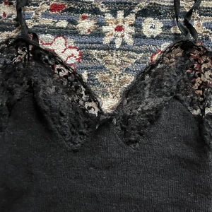 Stickat spetslinne, i 100% lana wool! - Svart stickat spetslinne med rosett, i 100% lana wool! Tillverkat i Italien av mjukt material. Perfekt för en stilren look.