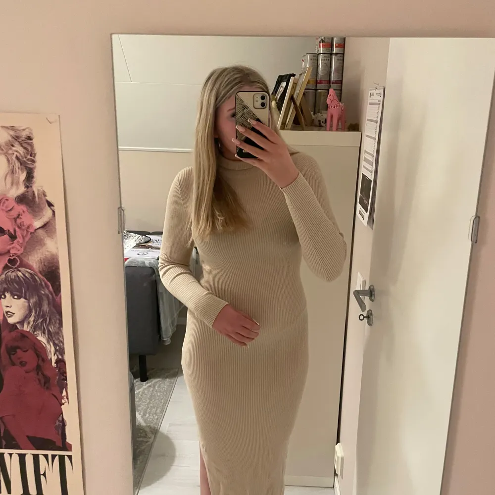 Snygg beige långklänning med ribbad struktur och lång ärm. Klänningen har en slits som ger en extra touch. Använd endast 1-2 gånger🤗. Mekot.