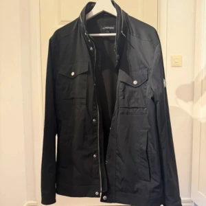 J.Lindeberg field jacket bailey - Snygg svart field jacket från J.Lindeberg                     Skick 9/10                                                                                Storlek L                                                                            Nypris 3400kr