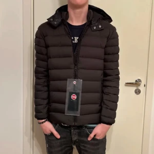 Svart pufferjacka med huva - Snygg svart pufferjacka från Save the Duck med huva och dragkedja. Perfekt för kyligare dagar. Jackan har en stilren design och är lätt att matcha med olika outfits.