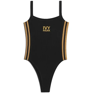 Svart body från Ivy Park(Beyonce) - Trendig svart baddräkt från Ivy Park med guldiga ränder längs sidorna och logotyp framtill. Den har en ribbad textur och smala axelband. Perfekt för en stilren look. Den är från Beyonce första collection och är helt ny och oanvänd. Passar mellan s-lx då materialet är super stretchigt. Köpt för 949kr plus frakt. 