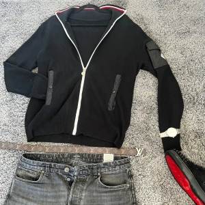 Moncler cardigan  - Snygg svart ribbad tröja från Moncler med dragkedja framtill. Tröjan har långa ärmar och stilrena detaljer i form av knappar på fickorna. Perfekt för en trendig look. Dm för frågor osv, buda så är den din💯💯