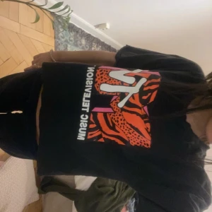 Svart MTV t-shirt - Cool svart t-shirt med färgglatt MTV-tryck i orange och rosa. Perfekt för dig som gillar coola t-shirts 