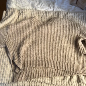 Beige stickad tröja från Gina Tricot - Säljer en mysig beige stickad tröja från Gina Tricot. Tröjan är ”delad” på två längst ner på armarna och även längst ner på tröjan på båda sidorna. Hör av dig vid intresse!💞☺️
