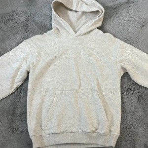 Vitmelerad hoodie från H&M - Säljer en klassisk hoodie från H&M.  Den är tillverkad i en mjuk bomullsblandning med 80% bomull och 20% polyester. Hoodien har en rymlig ficka framtill och en bekväm huva. Perfekt för en avslappnad stil. Det är svårt att avgöra vad den är för färg. Enligt mig så är ljusgrå/ljusbeige, men på hemsidan står det att den är vitmelerad. 🌟
