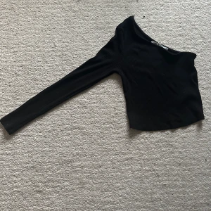 Svart ribbad oneshoulder topp - Snygg svart ribbad oneshoulder topp med lång ärm. Från NAKD, jättefint skick!!🫶🏼🩷 Storlek:S