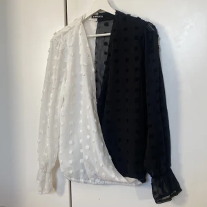 Svart/vit blus - Svart/vit tunn blus som är öppen hela vägen ner , dvs urringningen. Märke Sheilay.