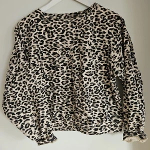 Leopardmönstrad tröja - Säljer en leopardmönstrad tröja med långa ärmar och kortare modell. Tröjan har en lös passform och är perfekt för att ge en djärv touch till din outfit. Den är tillverkad i ett mjukt material som känns skönt mot huden.