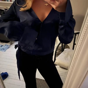 Mörkblå blus - Säljer en stilren mörkblå blus med långa ärmar. Passar till många olika outfits. Man knyter den med snören och knäpper en knapp🩷