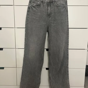 Gråa Hm jeans - Säljer ett par gråa jeans ifrån Hm, då de inte kommer till användning längre. Är utsvängda och höga i midjan. Stl 38 och passar mig bra som är ca 170💕