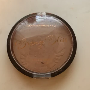Bronze Bliss Face & Body Bronzer - Bronze Bliss Face & Body Bronzer från Makeup Mekka ger en solkysst look med sin varma, bruna nyans. Perfekt för både ansikte och kropp. Kompakt förpackning med genomskinligt lock och elegant guldtext.testad  fåtal gånger på handen..!!! Annars oanvänd. Kan ksk sänka pris!