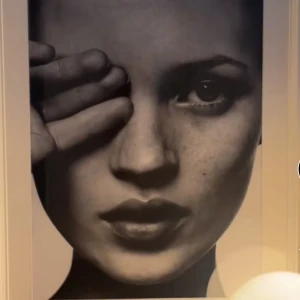 Tavla - Svartvit fotoposter av ett ansikte med en hand vid ögat. Stilren och modern design som passar i de flesta inredningar.