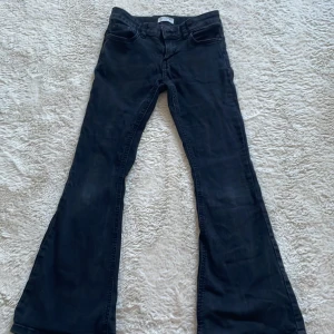 Svarta bootcut jeans från Lindex - Snygga svarta bootcut jeans från Lindex. De har en klassisk femficksdesign och en bekväm passform. Perfekta för en stilren look. Jättefina och inte så väl använda eftersom att jag växt ur dom.