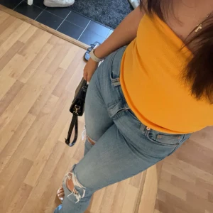 Gul ribbad tubtopp - Säljer en snygg gul ribbad tubtopp. Perfekt för sommardagar och kan enkelt matchas med jeans eller kjol. Toppen är stretchig och bekväm att bära.