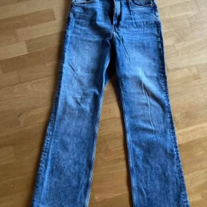 Blå jeans från Monki - Snygga blå jeans från Monki tillverkade i denim. Längd 80 cm. Vida i modellen, hög midja.