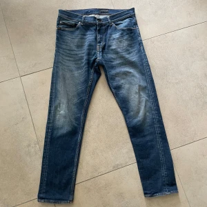 Tiger of Sweden jeans  - Snygga blå jeansbyxor med en klassisk femficksdesign och lätt slitna detaljer för en trendig look. Byxorna har en dragkedja och knapp framtill. Perfekta för en avslappnad stil. W32xL32 slim fit, passar och sitter väldigt skönt. Skriv vid minsta fundering. Otroligt bra skick! 