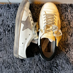 Vita sneakers med stjärndetalj - Snygga vita sneakers från golden goose skicket är 9/10 då de är nästan nya. De är i storlek 40 men sitter mer som 41-41,5, vid frågor är det bara att höra av sig!